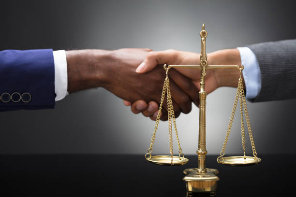 istock Golden Scale In Front Of Two Businesspeople Shaking Hands 929215590