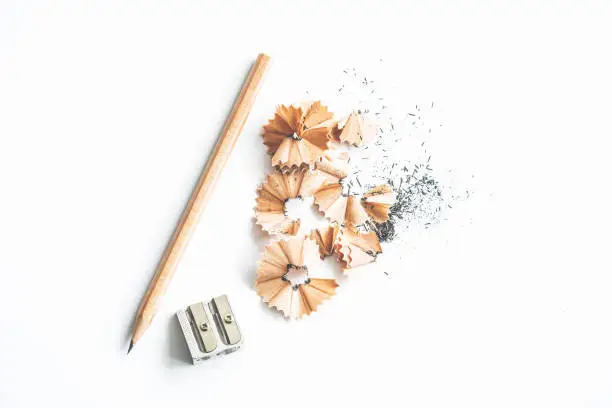 Pencil sharpener and pencil shavings on white background