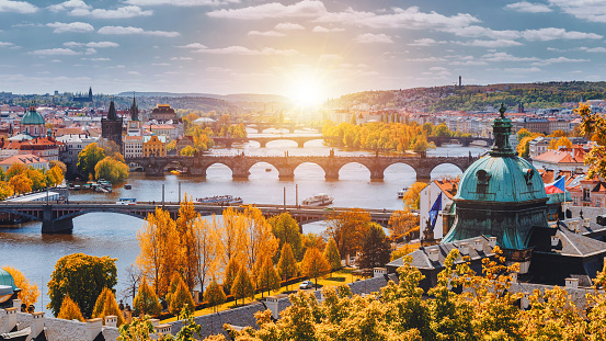 Vista a los puentes históricos, casco antiguo de Praga y río Moldava desde el punto de vista popular en el parque de Letna (Letenské sady), paisaje de otoño en suave luz amarilla, República Checa photo