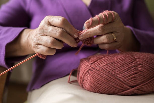 women is learning to knitting amigurumi for web amigurumi figures are in a basket on floor women is looking laptop