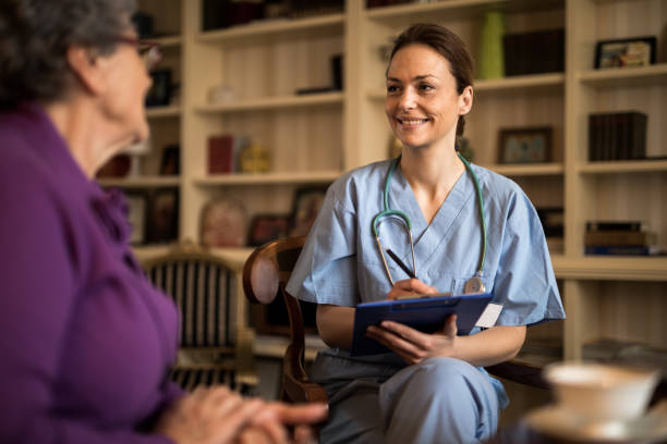 istock Home caregiver nurse talking with her patient 929244956