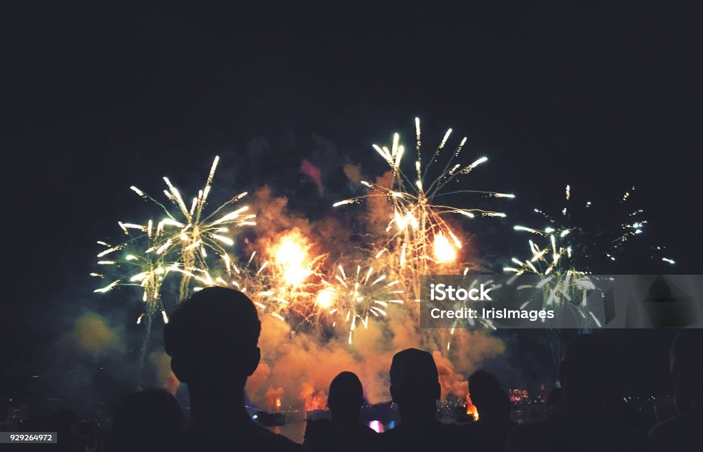 Siluetas de gente viendo un fuegos artificiales exhibición - Foto de stock de Fuegos artificiales libre de derechos