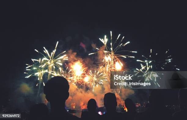 Silhouetted People Watching A Fireworks Display Stock Photo - Download Image Now - Firework Display, Firework - Explosive Material, Fourth of July