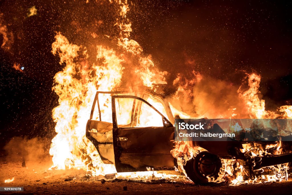 Car Engulfed in Flames A station wagon burns brightly at night. Burning Stock Photo