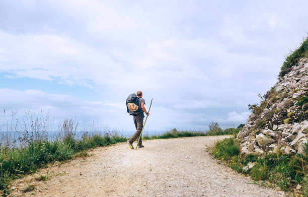 Backpacker traveler walks on road Backpacker traveler walks on road camino de santiago photos stock pictures, royalty-free photos & images