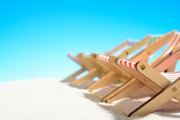 istock Multi-colored lounge chairs in a row on the sandy beach. 929334422