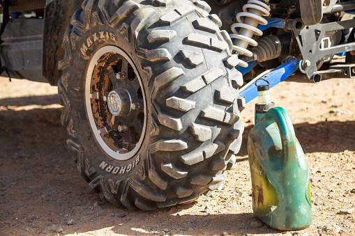 Merzouga, Morocco - February 24, 2016: Closeup up of quad wheel and oil can used for lubricating quad bike at desert repair station at Merzouga, Morocco.