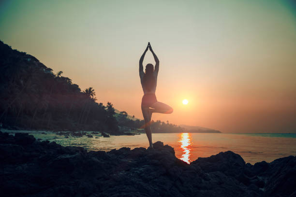 istock Woman practicing yoga on the beach 929339828