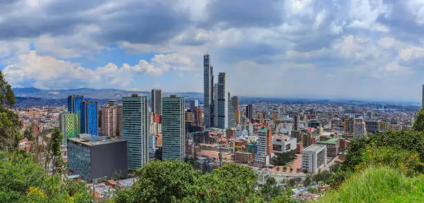 Bogota, Colombia - High angle view of the downtown district in the Andean capital city of Bogota, Colombia in South America. To the centre is the BD Bacatá, the tallest man made structure in Colombia. Located at over 8600 feet above mean sea level, with a population of almost 10 Million, Bogota is one of the largest cities in Latin America. Photo shot in the morning sunlight; panorama created in Adobe Lightroom. The location from where the image was shot makes it an uncommon image: not many photographers will stop at the location with an expensive DSLR. The area is considered as high risk for mugging and even stabbing. Camera: Canon EOS 5D MII. Lens: Canon EF 24-70 F2.8L USM.