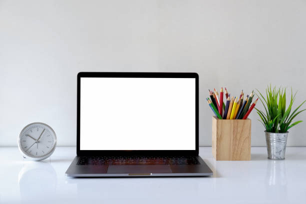 istock Blank screen laptop computer with office supplies on white wooden table 929367924