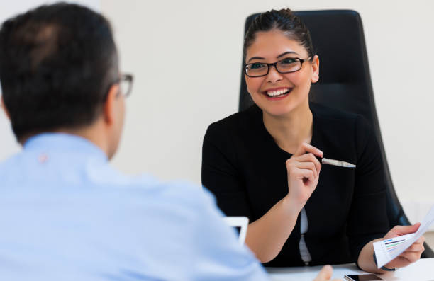 istock Businesswomen with paperwork talking face to face 929394432