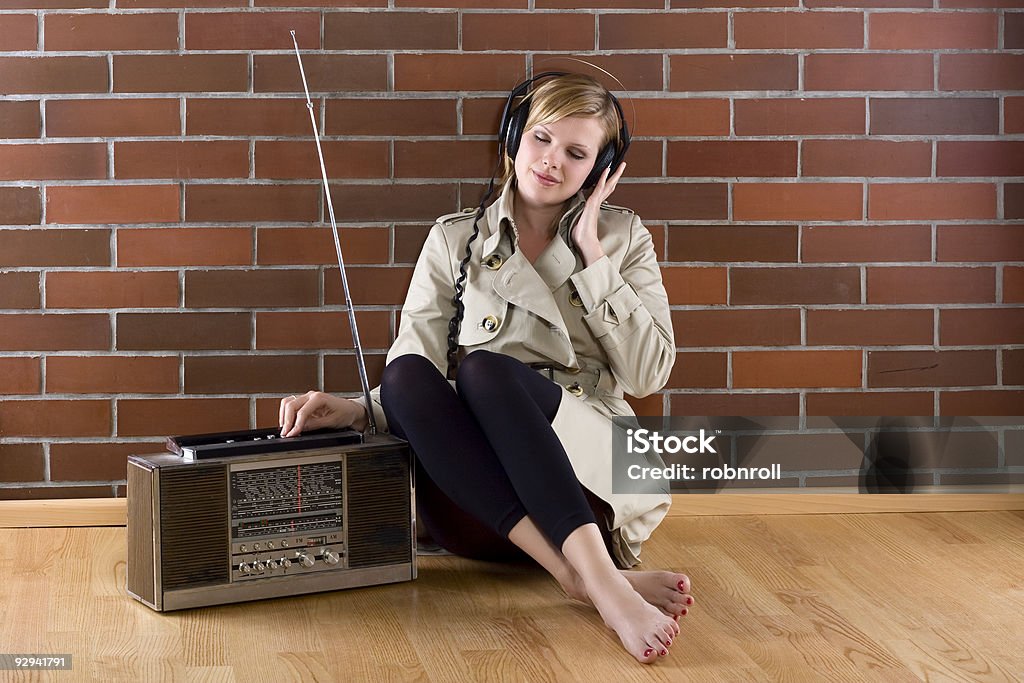 Donna Ascolta una vecchia radio - Foto stock royalty-free di Donne