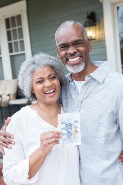 Proud parents hold photo of soldier son Proud mature African American parents hold up a photo of their son who is deployed overseas. proud army mom stock pictures, royalty-free photos & images