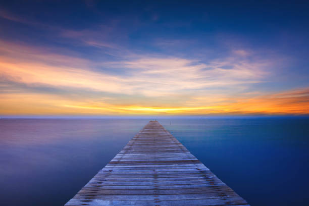 istock Wooden bridge on sea at sunset 929437422