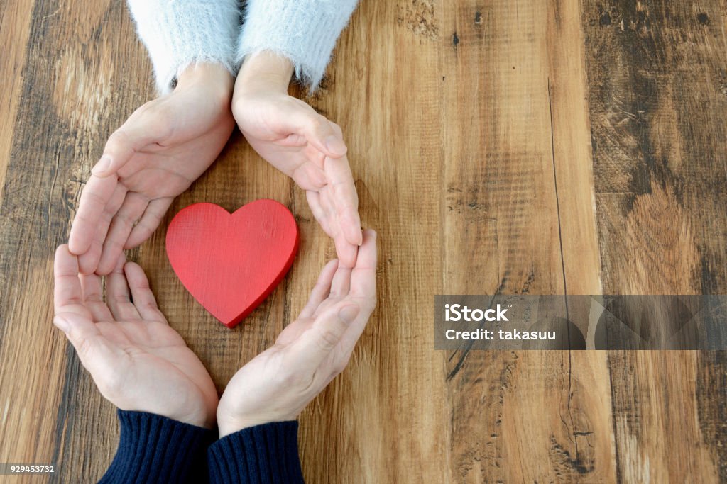 Corazón rodeado por mano de hombre y de mujer - Foto de stock de Símbolo en forma de corazón libre de derechos