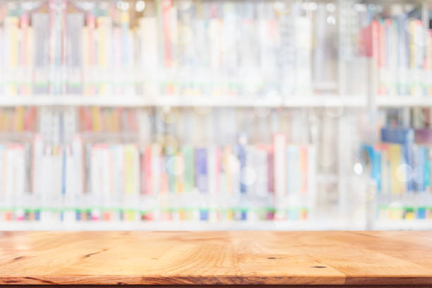 istock Empty top of wood table with blurred many books on bookshelf in library background. 929473786