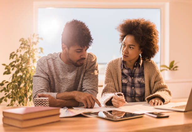 istock African American couple analyzing their housing project on a blueprint at home. 929474584