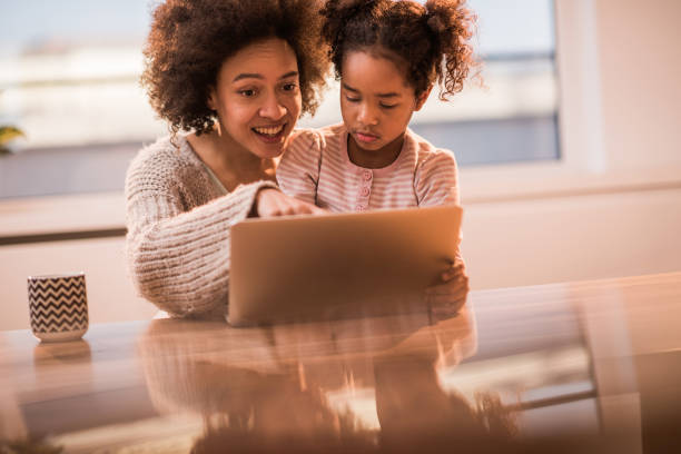 istock Happy black mother and daughter using laptop at home. 929482880