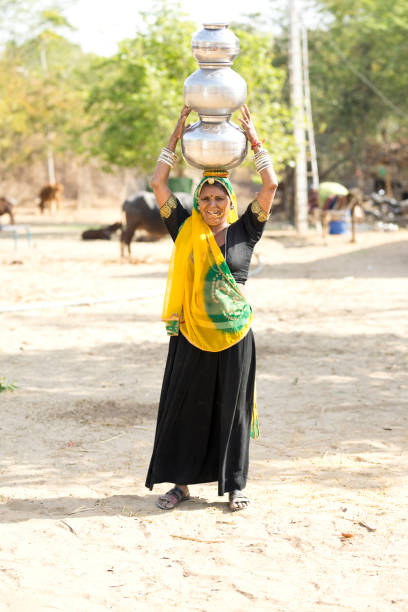 istock Indian woman carrying water pots on her head 929485976
