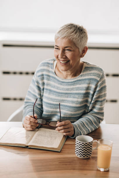 istock Happy senior woman taking a break from reading a book. 929487428