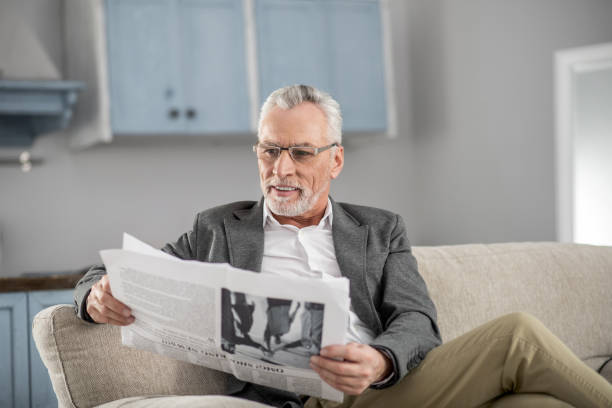 istock Happy mature man looking at newspaper 929490442