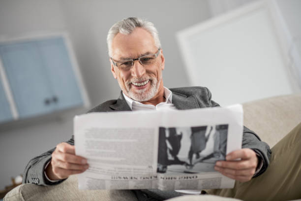 istock Cheerful gray-haired man enjoying morning press 929490536