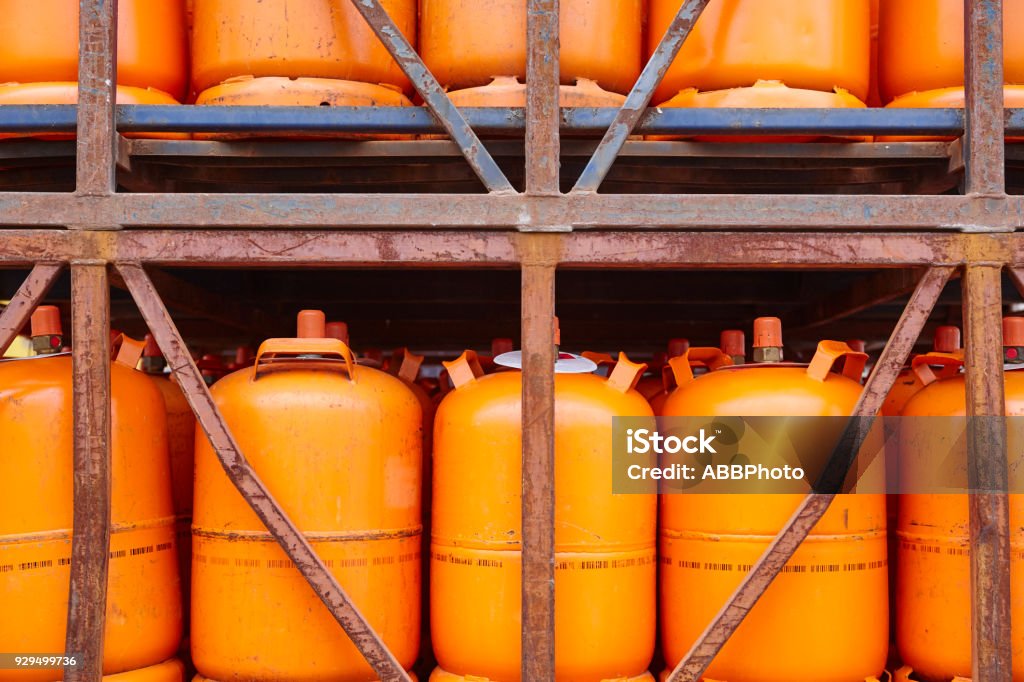 Used gas butane cylinder containers in orange tone Used gas butane cylinder containers in orange tone. Horizontal Canister Stock Photo