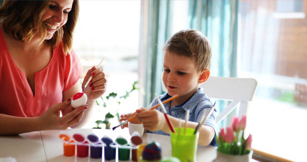 istock Mother and son are painting eggs 929503790