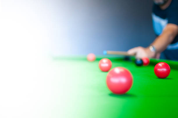 istock Man playing on a snooker table with pool balls and cue 929506216