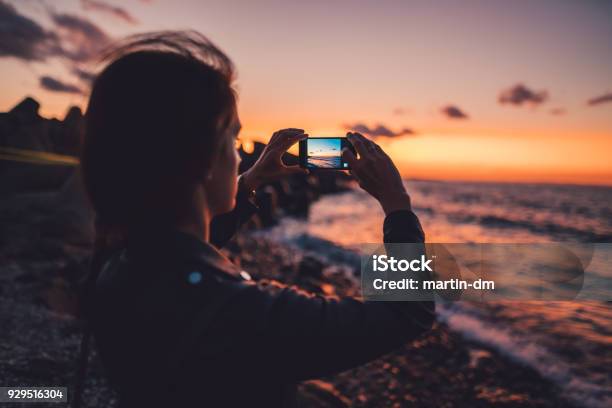 Woman At The Beach Photographing The Sunset Stock Photo - Download Image Now - Photography, Photograph, Photographing