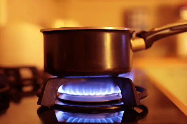 gaz range in kitchen with pan on it, shallow DOF, focus on pan