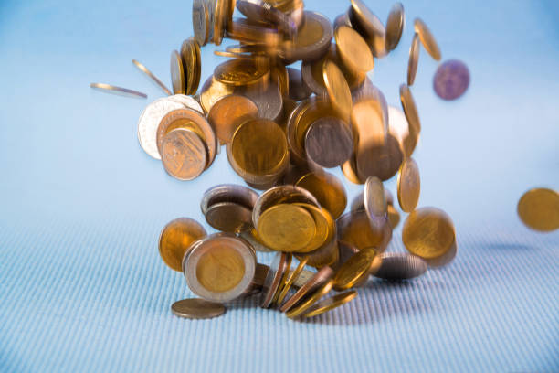 istock Falling coins money on blue background, business wealth concept. 929519220