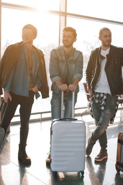 istock Smiling friends with luggages situating in hall 929526092