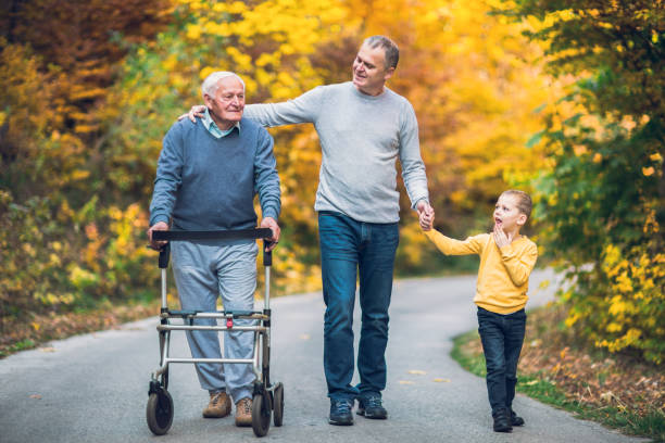 anciano padre hijo adulto y nieto hacia fuera para una caminata en el parque. - walking senior adult family old fotografías e imágenes de stock