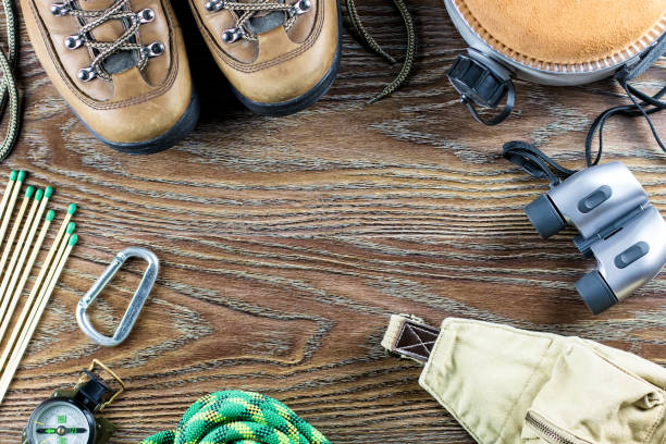 istock Hiking or travel equipment with boots, compass, binoculars, matches on wooden background. Active lifestyle concept 929542270