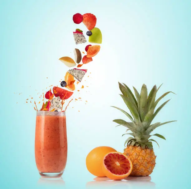 Smoothie drink with fruit flying ingredients, isolated on gradient background. Healthy drink and lifestyle