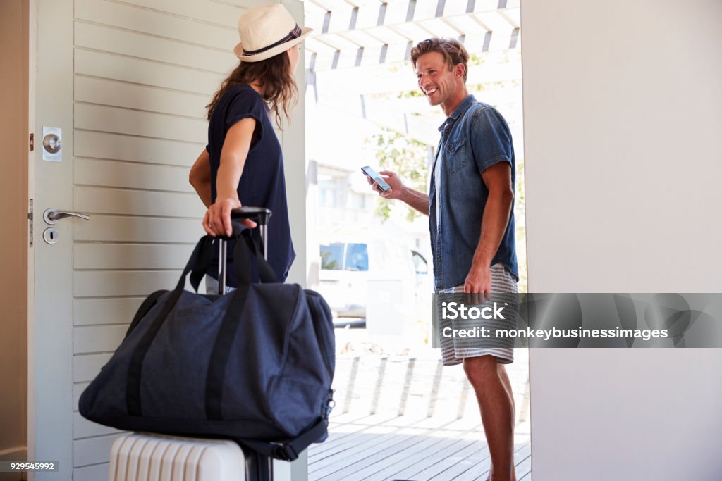 Couple Using Online App To Book Cab For Vacation Leaving Stock Photo