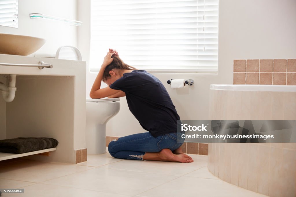 Woman Suffering With Morning Sickness In Bathroom At Home Vomit Stock Photo