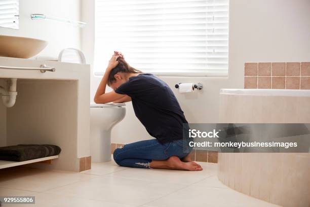 Woman Suffering With Morning Sickness In Bathroom At Home Stock Photo - Download Image Now