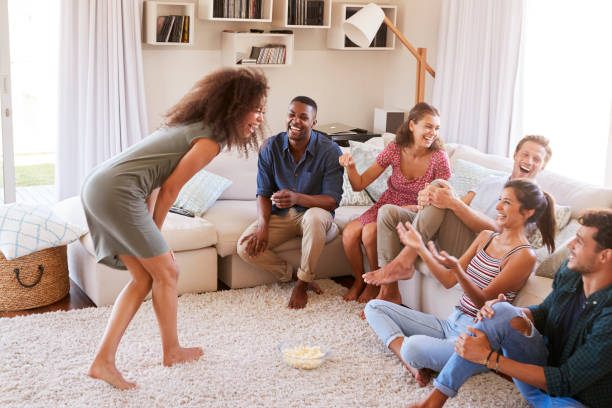 Group Of Friends At Home Having Fun Playing Charades Together Group Of Friends At Home Having Fun Playing Charades Together pantomime stock pictures, royalty-free photos & images