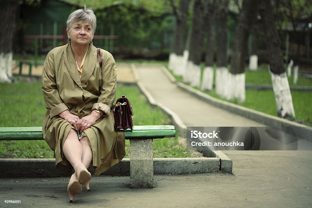 Invecchiato donna seduta nel parco - Foto stock royalty-free di Panchina