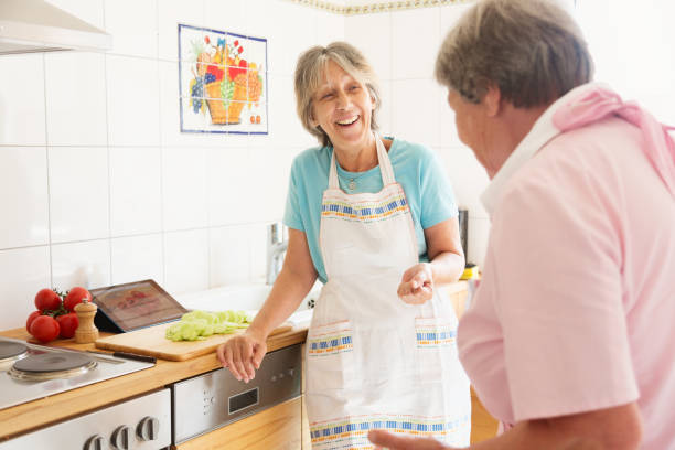 istock Senior women cooking together in kitchen  chatting 929564508