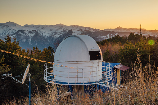 Small astronomical observatory with telescope in Caucasian mountains at the sunset.
