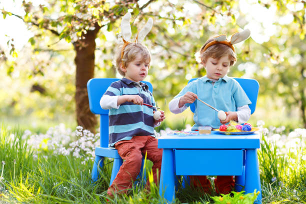 istock Two little boys wearing Easter bunny ears, painting colorful egg 929571616