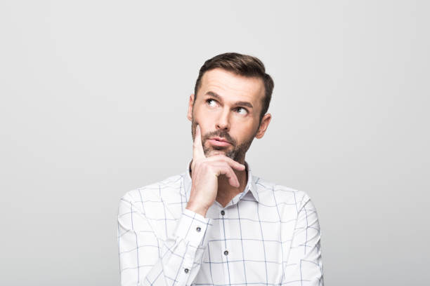 istock Portrait of pensive, handsome man, grey background 929585156