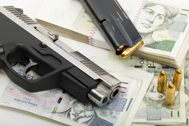 Photo of gun and czech banknotes, crime concept