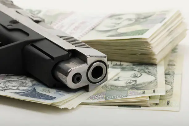 Photo of gun and czech banknotes, crime concept
