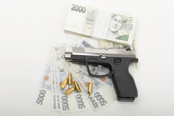 Photo of gun and czech banknotes, crime concept