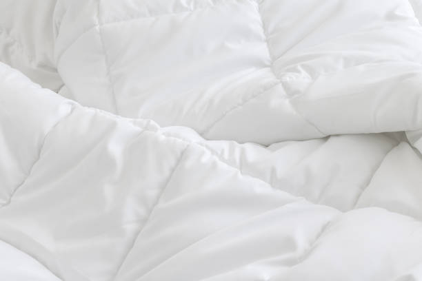 White bedding sheets background. Messy bed concept. White bedding sheets background. Messy bed concept. duvet stock pictures, royalty-free photos & images