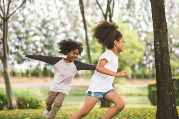 bambina che gioca con l'amico - spring child field running foto e immagini stock